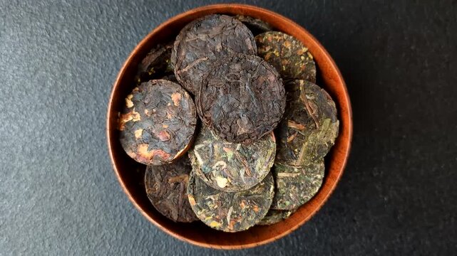 Organic Chinese green pu-erh tea with various herbs in round bricks. Chinese pu-erh tea as a background for your design