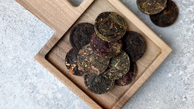 Organic Chinese green pu-erh tea with various herbs in round bricks. Chinese pu-erh tea as a background for your design