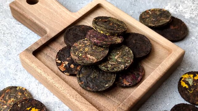 Organic Chinese green pu-erh tea with various herbs in round bricks. Chinese pu-erh tea as a background for your design