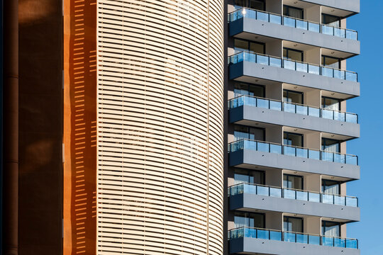 Facade of a modern apartment building in spain where balconies follow gentle curves on a residential highrise creating elegant architecture rhythm