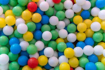 Obraz premium A ball pit filled with numerous multicolored plastic balls. Childhood, recreation, early education, and sensory play environments concept.