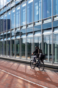 Clean commercial bicycle cyclist commute along urban street beside building glass reflections and transport lifestyle in Hamburg Germany