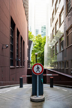 Modern urban alley street with empty pavement perspective sign and bollards guiding wayfinding direction and quiet city navigation through a narrow route