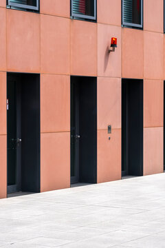 Empty pavement in front of a modern urban facade with door and wall forming simple architecture shapes and clear wayfinding orientation in the city