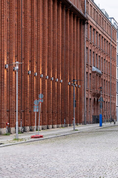 Brick warehouse facade along an empty urban street with industrial mood pavement perspective and clear wayfinding geometry in a quiet district