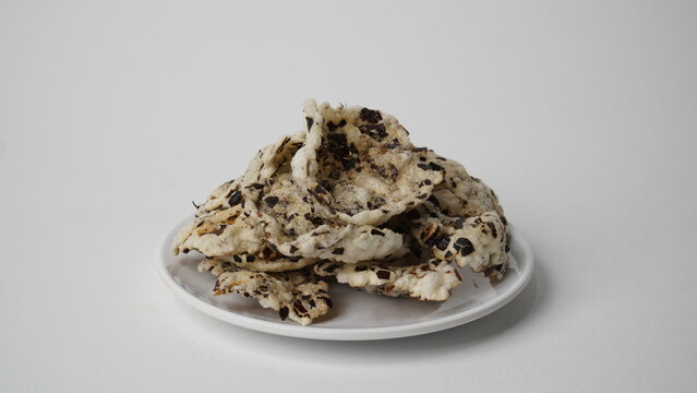 Tike chips or keripik tike, a traditional snack from Indramayu, Indonesia, made from nutgrass tubers, served on a white plate.