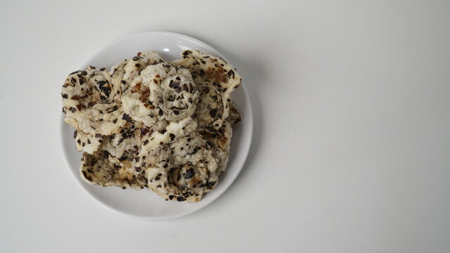 Tike chips or keripik tike, a traditional snack from Indramayu, Indonesia, made from nutgrass tubers, served on a white plate.