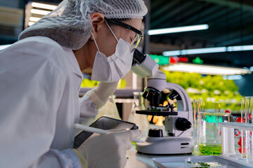 A researcher in a sterile lab conducts a scientific experiment using a microscope and test tubes. Cutting edge biotechnology and chemistry help develop breakthroughs in medicine and healthcare. © ultramansk