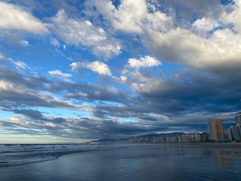 nuvens  e ceu azul em um amanhecer na praia na cidade de  Praia Grande