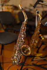 Obraz premium Saxophones are placed on stands in a music studio ready for a recording session near the end of the day