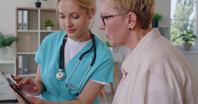 Doctor and nurse guide senior patient during consultation. In medical clinic, they discuss diagnosis, treatment options, and preventive healthcare services. Concept patient care and medicine.