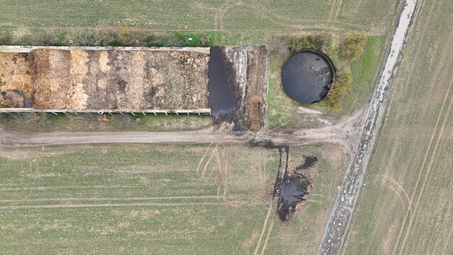 Manure storage tank lagoon pit submerged slurry collect and store liquid livestock pollution contamination groundwater solid waste bedding straw or corn stalks stored pile stinking unpleasant smell