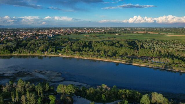 Po River reflecting blue sky with Cremona city and Torrazzo bell tower establishing the natural border between Emilia Romagna and Lombardy regions