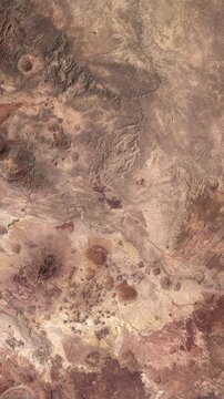 Top shot on red rocks and desert. Concept of landscapes of Mars. Camera is zooming in, rotating counterclockwise. Vertical video. Animation based on image by NASA