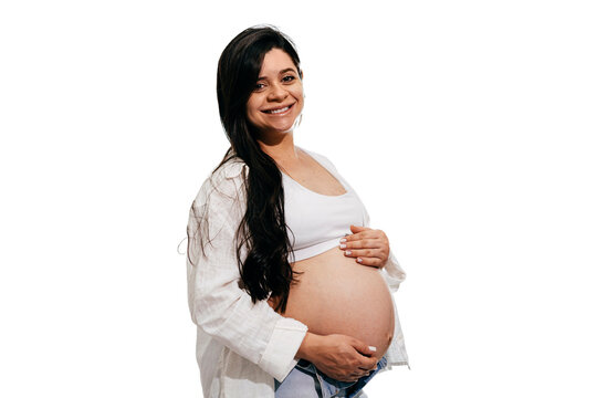 Pregnant woman smiling and holding her baby bump, representing maternity, confidence and happiness in pregnancy.