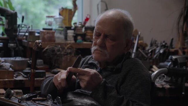 Elderly craftsman working in his old workshop, carefully restoring collectible Japanese bladed weapons