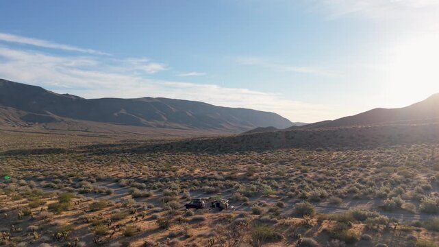Teardrop camper sits in the Anza Borego Desert watching the desert landscape as the sun sets in Plum Canyon in California.
