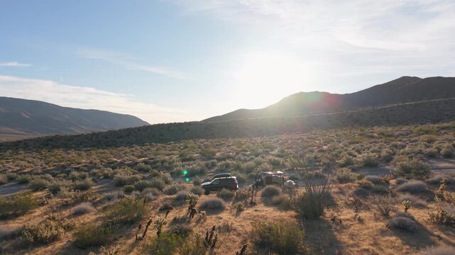 Teardrop camper trailer parks in Anza Borego Desert State Park as the sun sets over the landscape in Californias wilderness.