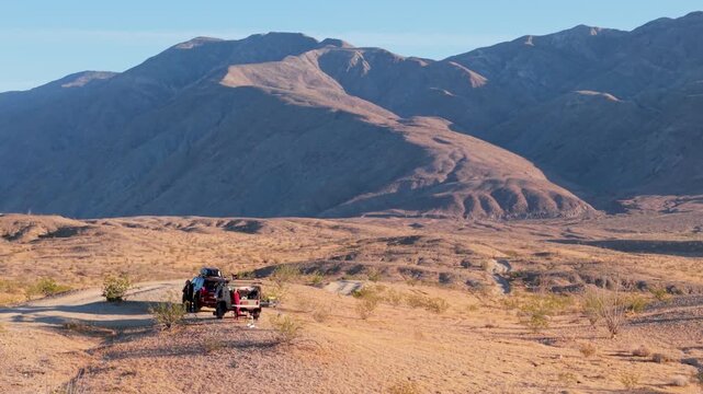 Watch a teardrop camper and an SUV parked in the Anza Borego Desert State Park near Thimble Trail while exploring the desert.