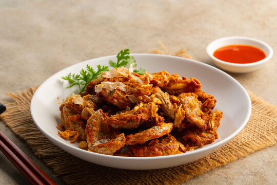 Deep Fried Pork Intestines with Crispy Garlic in white plate.with chilli sauce.