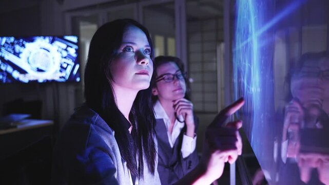 A professional man interacts with a high-tech circular data interface on a large digital screen, featuring graphs and data elements in a glowing blue theme.