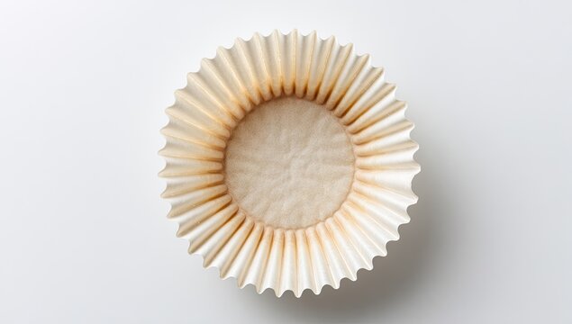 Empty fluted paper liner, light tan with slight brown staining, on white