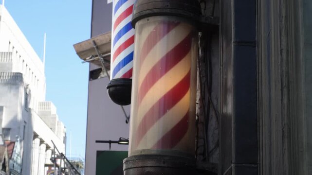 Rotating red and white barber pole close up traditional sign