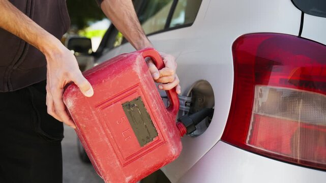 pouring gasoline with the jerry can into the car