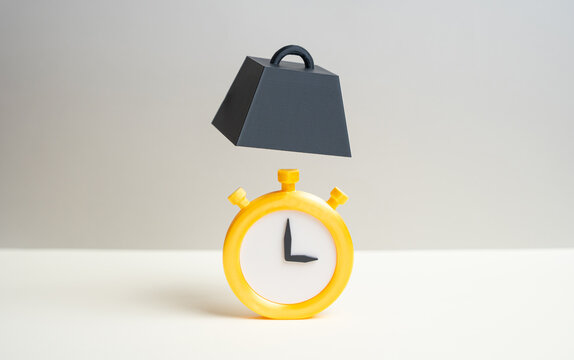 A clock and a falling weight. Pushing deadlines closer. Pressure and deadlines increase urgency. Time constraints impact decision making, stress levels and project execution.