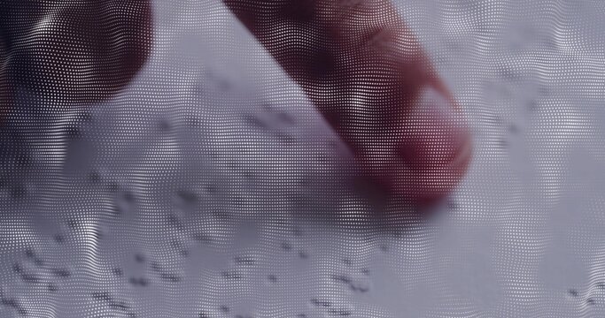 Pressing human fingertip on tabletop surface, showing fingernail, granular specks and halftone