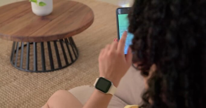 Adult woman tapping phone and starting smart home controls, app animating dials changing lights