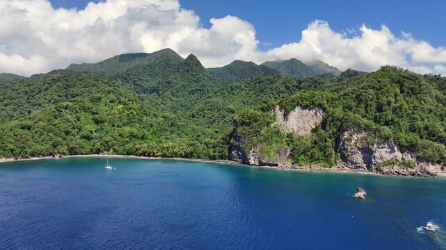 forward flying to famous Anse Couleuvre Beach at Le Pr&ecirc;cheur coastline in Martinique, with a final right pan along the lush green hilly vulcano landscape - 4k aerial video footage 