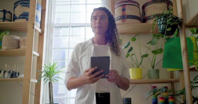 After handheld check, nonbinary African American person scanning tablet, logging baskets and plants