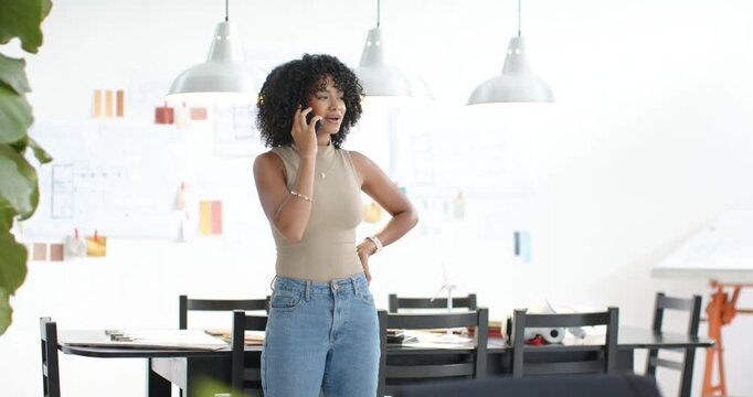 Vertical video: Answering call, woman in beige top placing phone on table in studio, about design