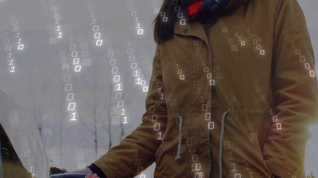 Woman in tan parka and red-blue scarf connecting EV charger to car outdoors under binary overlay
