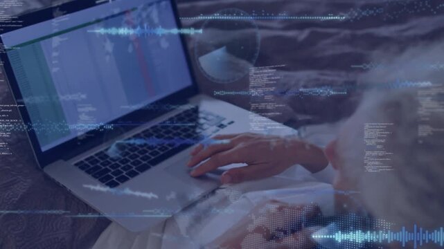 Woman reclining on bed tapping trackpad and bringing code waveforms over sheet for IT monitoring