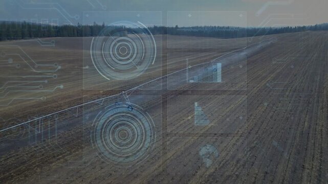 Vertical video: Rising drone filming pivot and wheels moving across field, tracking water with HUD