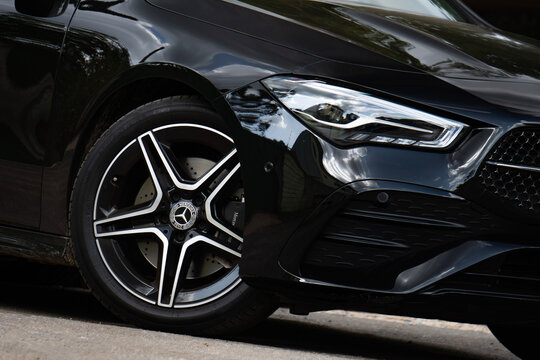 Black Mercedes CLA 200 front wheel and headlight angled shot, Luxury sedan styling outdoors