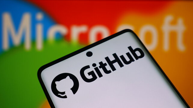 A smartphone displays the GitHub logo in front of a Microsoft background