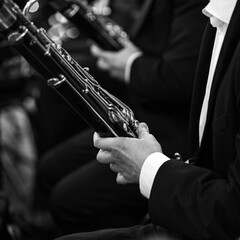Obraz premium Hands of a musician playing the bassoon in an orchestra in black and white