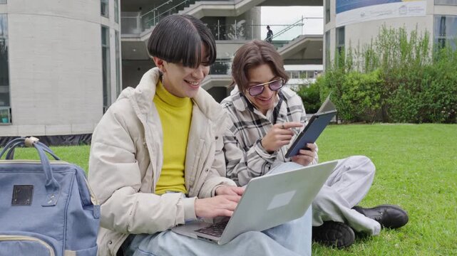 Two university students collaborating on a project outdoors