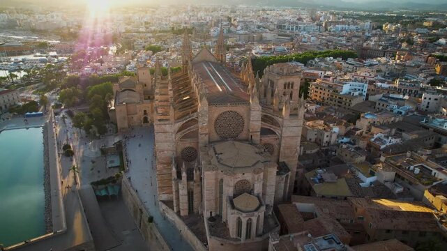 4K Cinematic Drone Orbit of Palma Cathedral at Sunset. Golden Hour Aerial View with Lens Flare and Sun Rays through Gothic Spires. La Seu Landmark, Majorca Spain. High Quality Video.