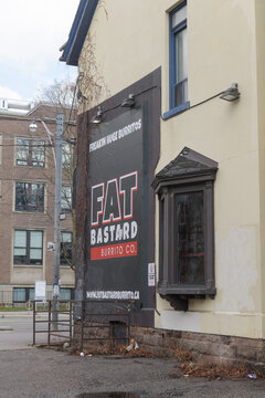 exterior wall and sign of Fat Bastard Burrito, a restaurant chain, located at 187 College St, Toronto