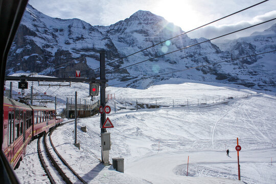 Red Jungfraubahn Train in Snowy Swiss Alps Mountain Landscape near Eiger and Monch