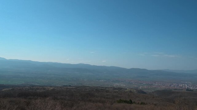 Blue sky stretches above rolling hills. Pirot city panorama
