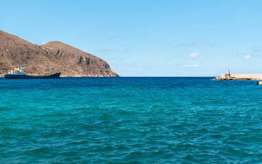 Naklejka premium Mediterranean Sea landscape from the seafront of Favignana Island, Province of Trapani, Sicily, Italy. Scenic coastal view featuring turquoise waters and rocky shoreline.