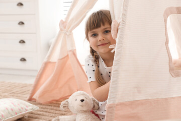 Little girl in toy wigwam at home © New Africa