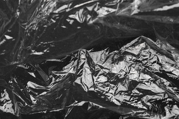 Naklejka premium Transparent plastic wrap on black background, closeup