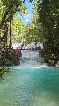 Beauty woman staying on scenic waterfalls in Luwuk, Central Sulawesi