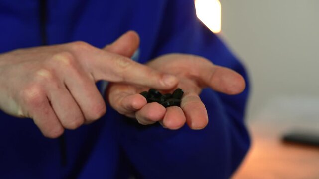 A patient in a blue cap holds many green pills in his hand.
Treatment of viral diseases during a pandemic.
Antipyretic tablets on the palm